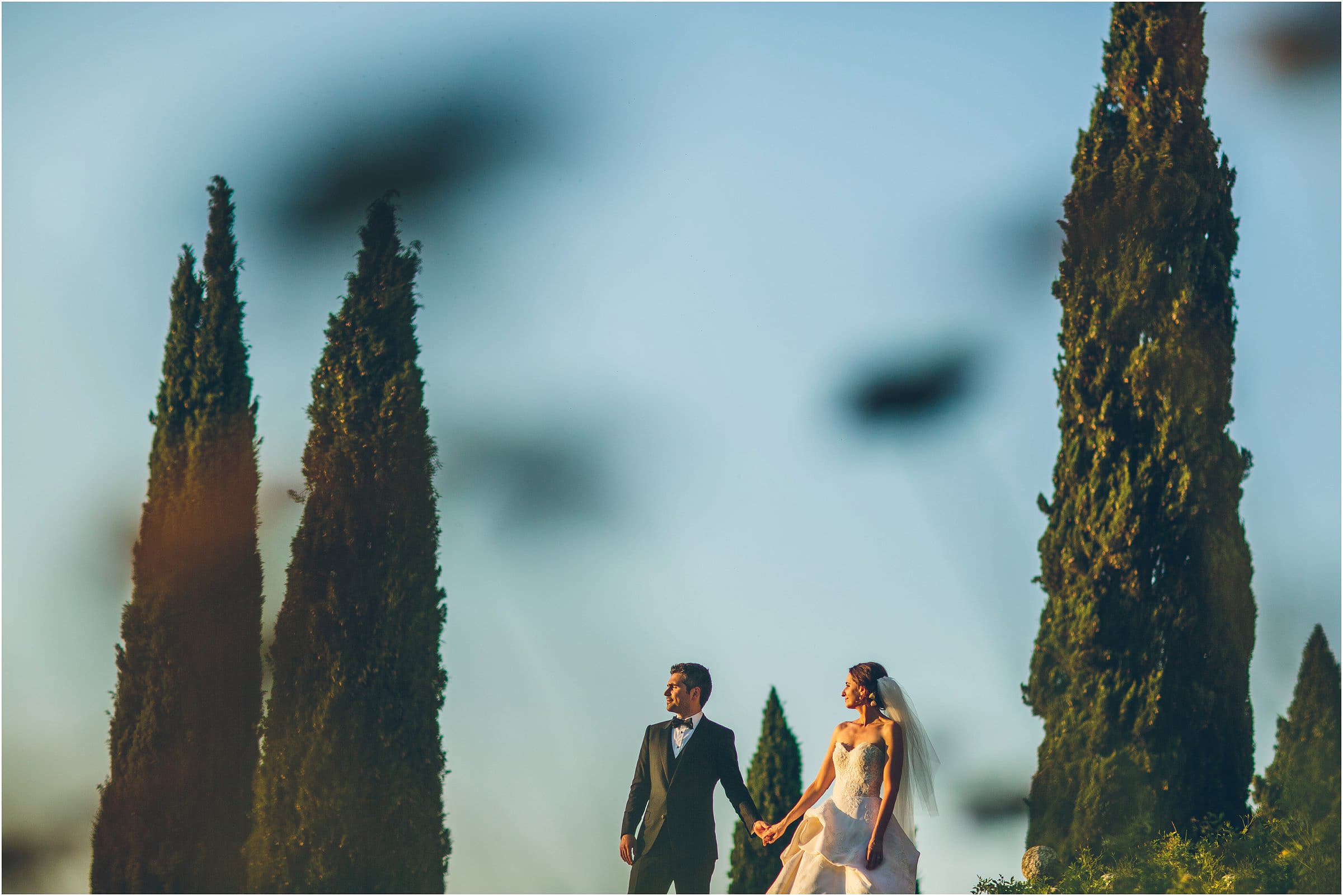 Destination wedding photograph in the tall trees at Castello di Vicarello in Tuscany