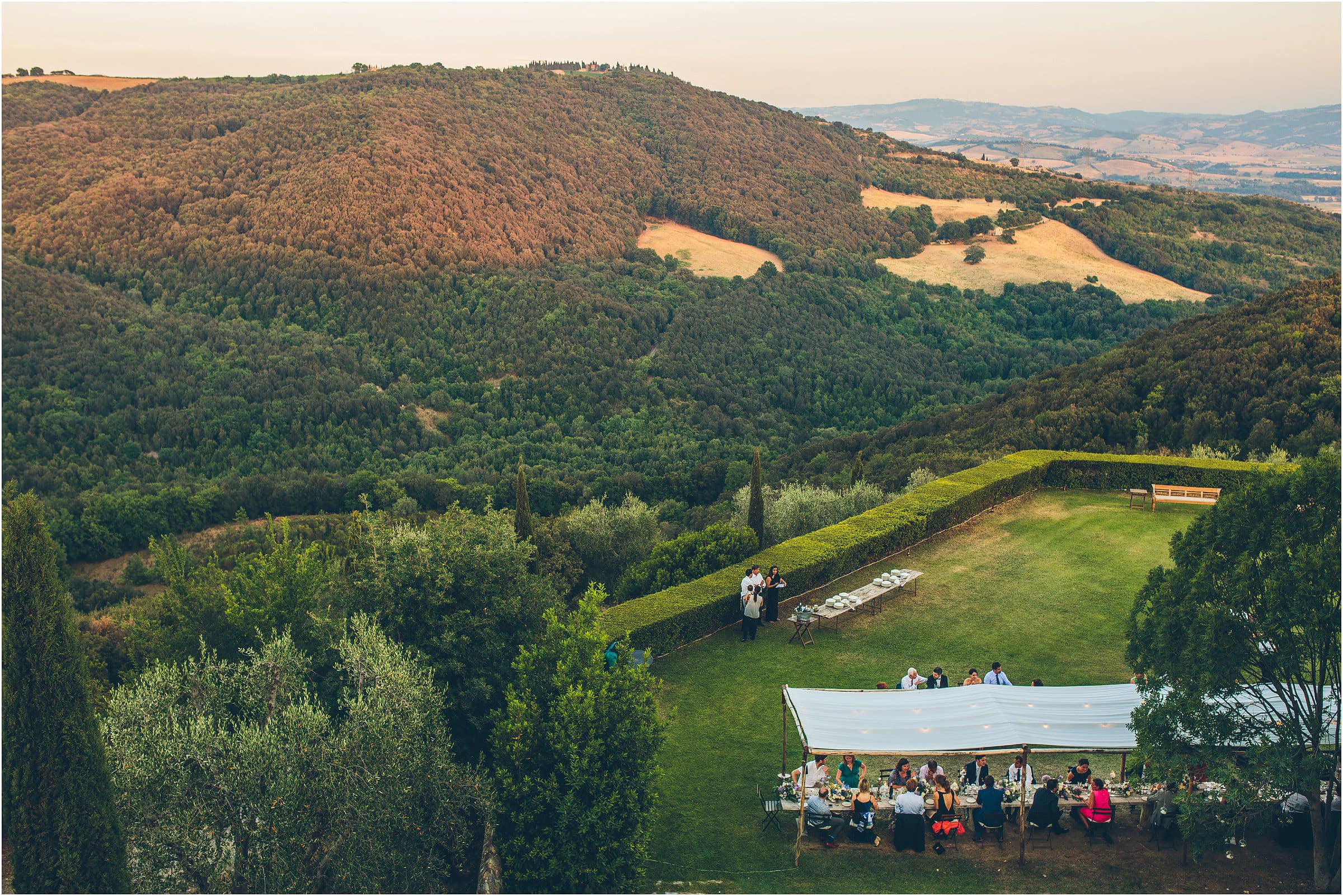 The hills around Castello di Vicarello in Tuscany in the evening sun as guests enjoy dinner outdoors